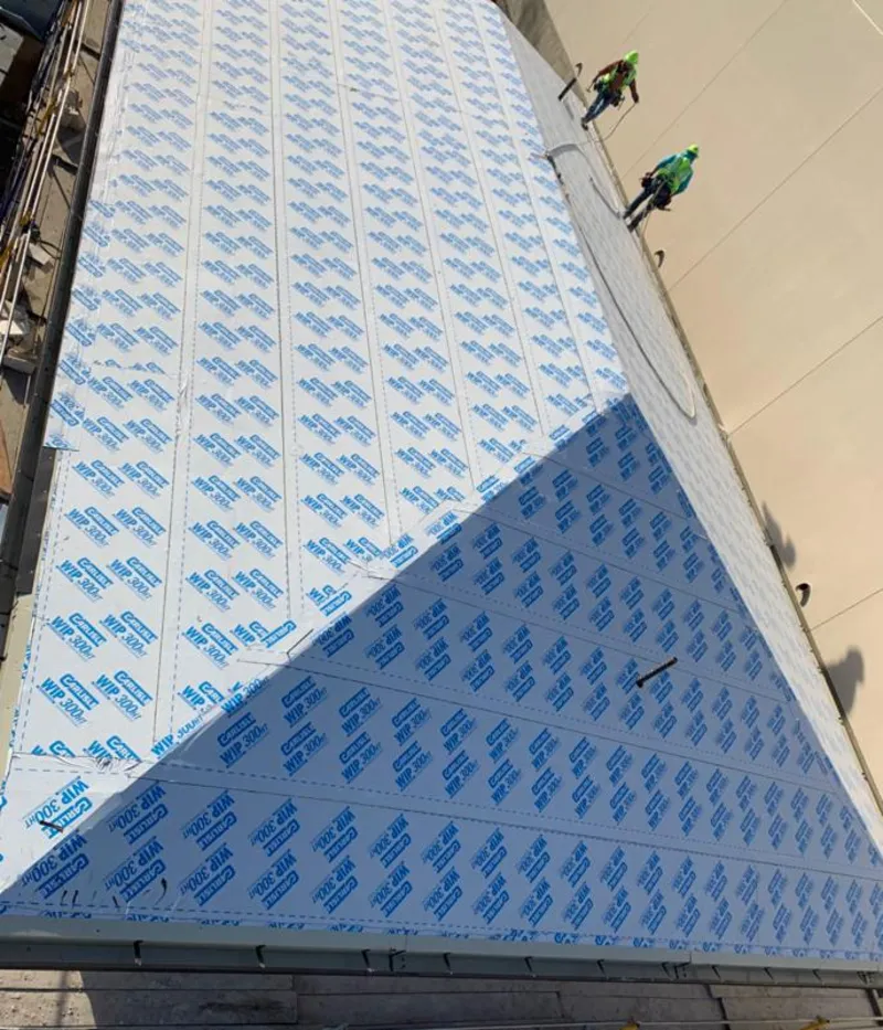 Professional roofers installing underlayment on a metal roof in Solebury